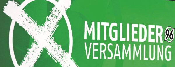 Weißes gemaltes X neben "MITGLIEDERVERSAMMLUNG 96" auf grünem Hintergrund.